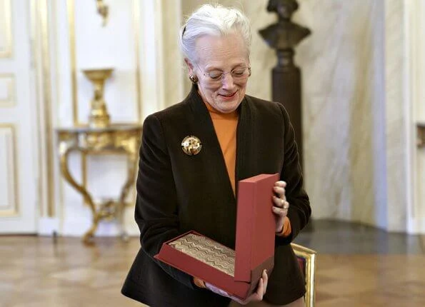 The National Museum presented a special edition of the museum's yearbook Nationalmuseets Arbejdsmark to Queen Margrethe. gold brooch