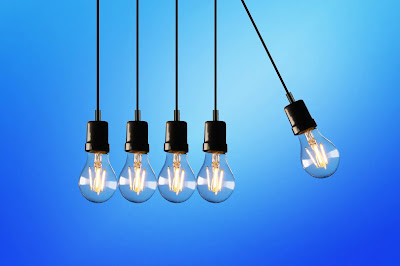 a pack of light bulbs arranged to create a pendulum