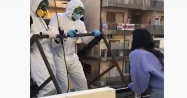 شاب يتسلق إلى شرفة حبيبته ببدلة العزل لطلب يدها