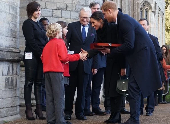 Meghan Markle carried Demellier London The Mini Venice Bag, Meghan Markle wore Tabitha Simmons Kiki boots, wore Theory wool jacket. wedding dress at ceremony