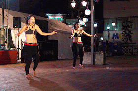 2 girls belly dancing, outdoors, night