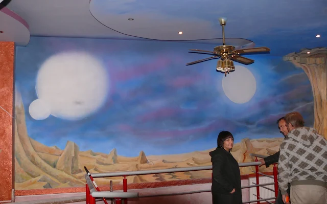 Aranżacja klubu poprzez malowanie obrazu na ścianie przedstawiającego kosmos, kosmiczny wystrój baru