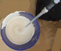 This is a side view of the paint being stirred by the paint paddle
