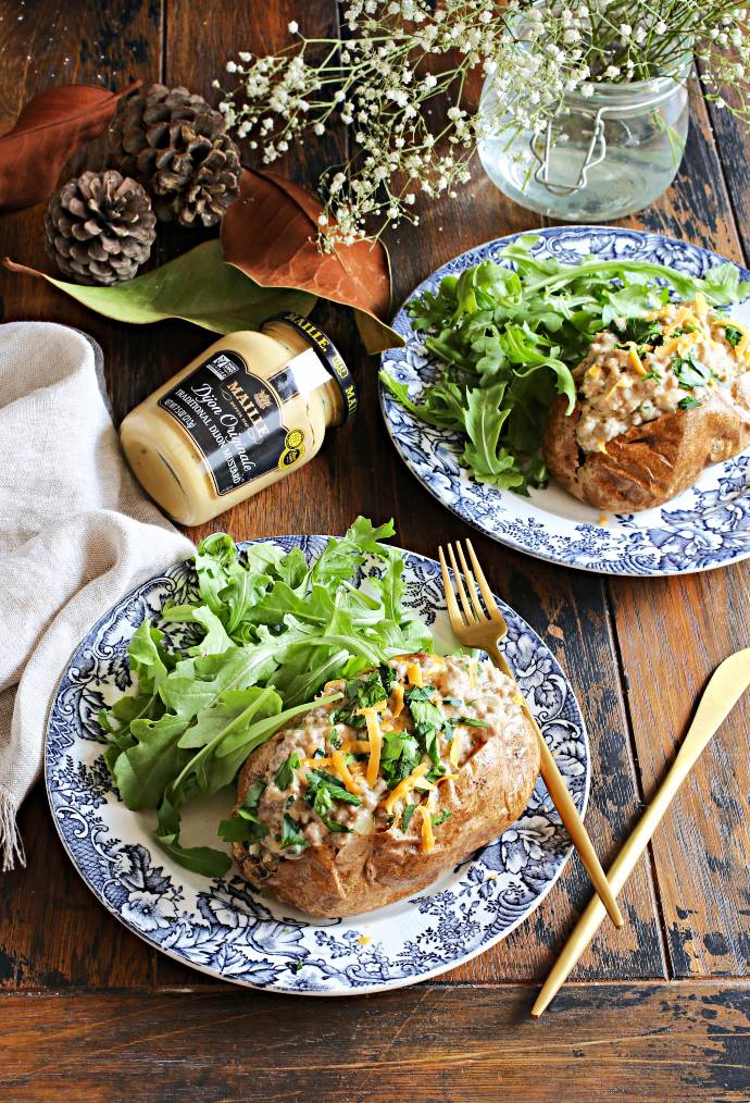 Recipe for browned ground beef cooked in a cheesy mustard bechamel sauce and served over baked potatoes.