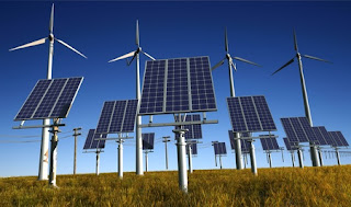 solar panels and wind turbine in a field of grass