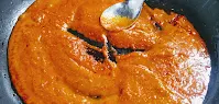 Cooking tomato paste (puree) in a pan for butter chicken Murgh makhani recipe