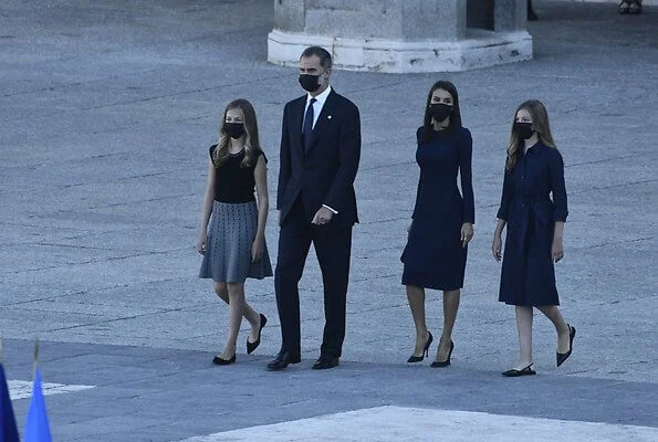 Letizia wears a navy blue dress by Carolina Herrera, Nina Ricci shoes and carries a clutch by Magrit. Princess Leonor and Infanta Sofia