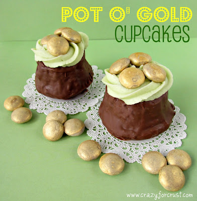 two cupcakes dipped in chocolate with green frosting and gold colored candy to look like pot o gold cupcakes with words on photo