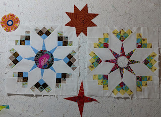 Two Shadow Star blocks on the design wall surrounded by three post choices: a flower medallion, a red four-pointed star, and a rust eight-pointed star.