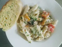 Pasta in white sauce with garlic bread