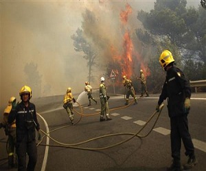 Firefighters controlling wildfire on the road between Marbella and Monda in Ojen, Southern Spain