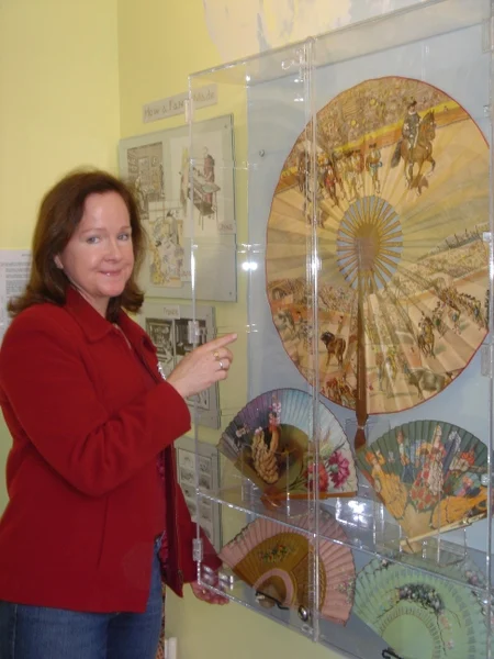 curator points at fans displayed at The Hand Fan Museum in Healdsburg, California