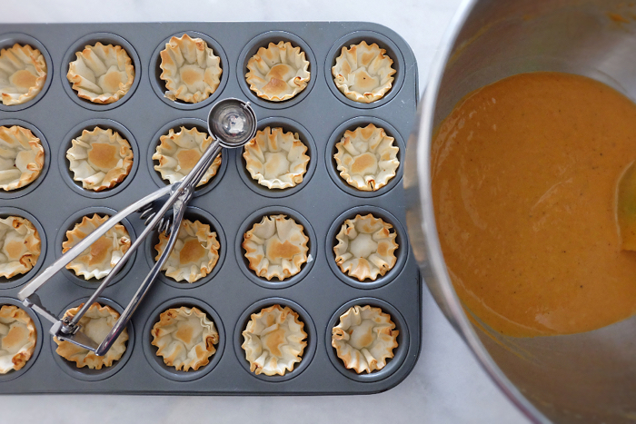 filling phyllo cups with pumpkin mix using a melon baller