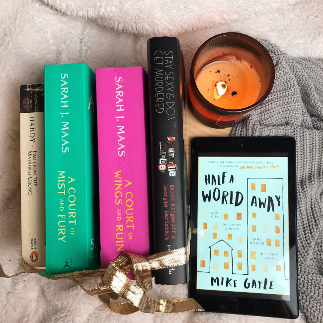 Top 10 books of 2020! Stack of books facing spine up next to a kindle showing the cover for 'Half a World Away' by Mike Gayle