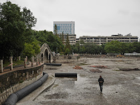 man walking in drained lake at Lianhu Square (莲湖广场) in Hengyang