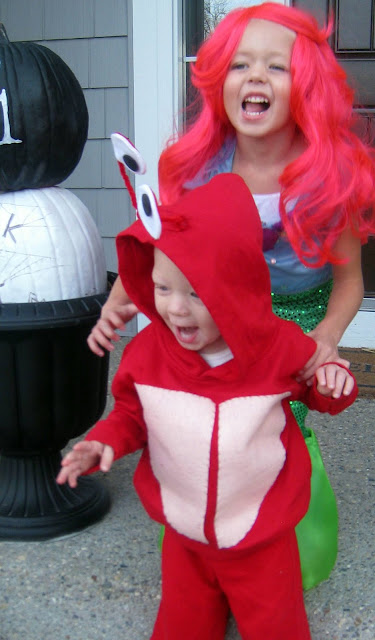 A little girl standing next to a person