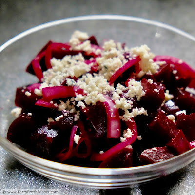 A close up image of roasted beets with pickled red onions and gorgonzola cheese.