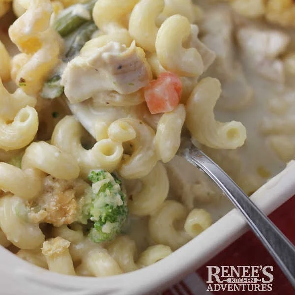 Creamy Chicken and Vegetable Casserole by Renee's Kitchen Adventures. Easy casserole made with leftover chicken, frozen vegetables, and pasta in a light and creamy sauce. Spoon serving up a serving from the casserole dish.