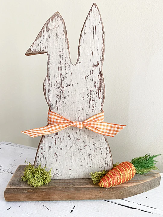 chippy Easter bunny on a picket fence with carrot and gingham bow