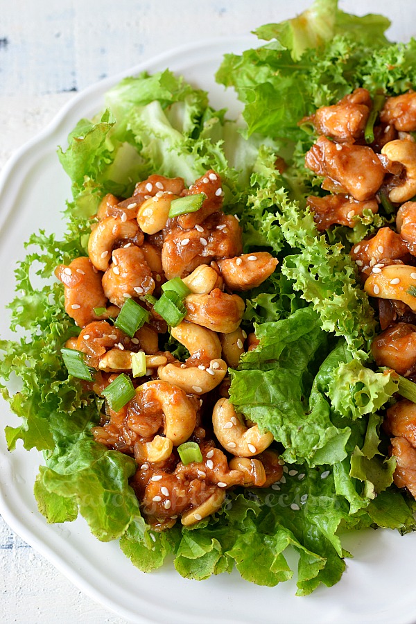 a close up of a plate with delicious cashew chicken stir fry lettuce wraps