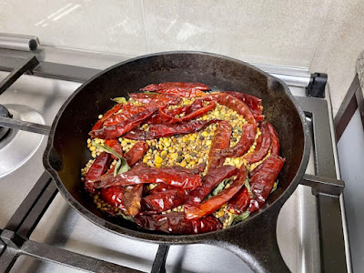 Sambar Powder ingredients roasted in a cast-iron pan