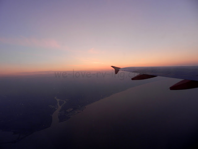 The sunrise is seen out the airplane window as we fly over Italy