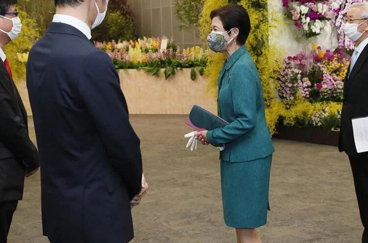 Tokyo Dome City Prism Hall. Japanese orchid flowers of the Ebine variety that bloom in many colors. Green skirt suit, gold earrings