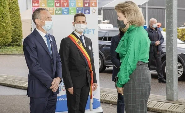 Queen Mathilde wore a new green bow blouse from Carolina Herrera and grey check print trousers from Natan. She visited the facilitys of Danone