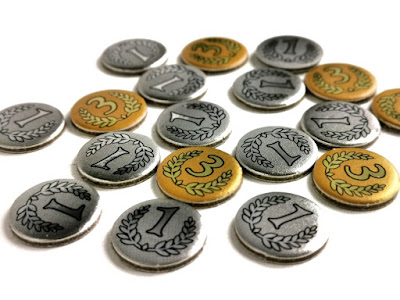 zdjęcie przedstawia rozsypane na stole złote i srebrne monety o wartościach jeden oraz trzy