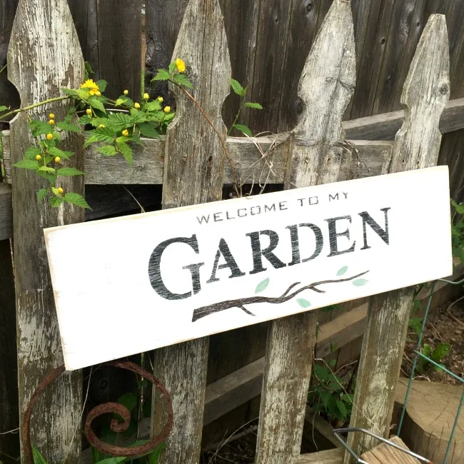 White garden sign in front of fence