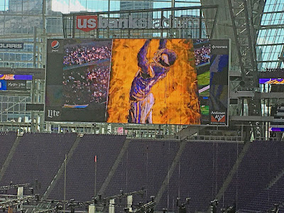 Football Art NFL Minnesota Vikings Football player painting by sports artist John Robertson projected onto the jumbotron TV screen at US Bank Football stadium