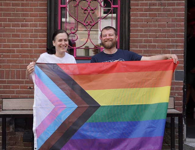 Boonstra en Van der Linden met de Pride-vlag in Amsterdam