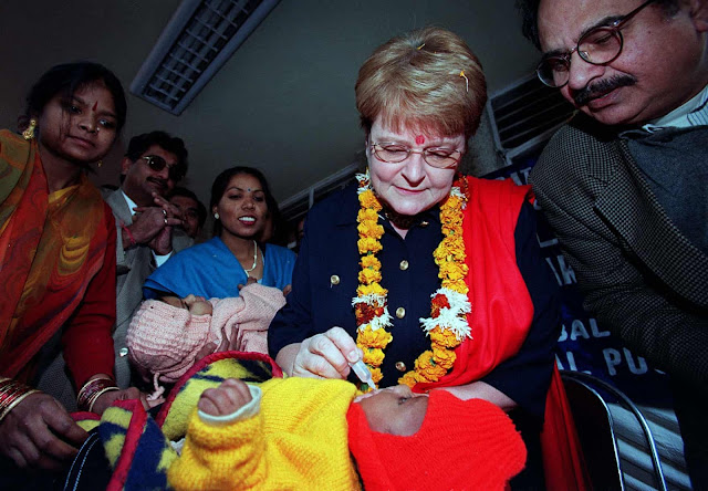 WHO director-general Gro Harlem Brundtland gives polio immunisation to a young boy in New Delhi