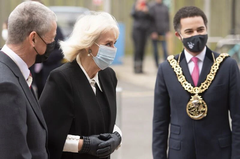 The Duchess wore a black cape and pearl earrings