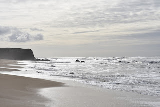 Silvery waves and a black cliff under gray, overcast skies, Pacific Ocean, Half Moon Bay, California