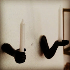 One-twelfth scale wall-mounted candle holders in the shape of human hands holding the candles.