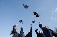 5 high school graduates throwing their caps in the air