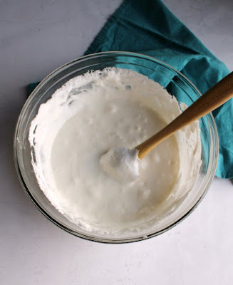 big glass bowl full of melted marshmallows and butter for popcorn balls