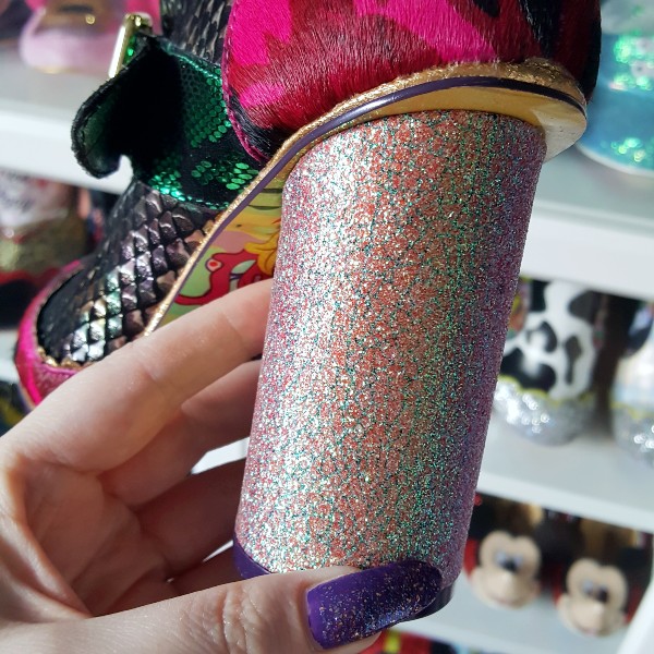 close up of round glitter heel on ankle boot, held in hand