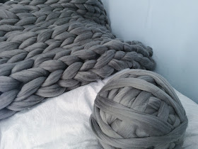 grey blanket next to ball of yarn