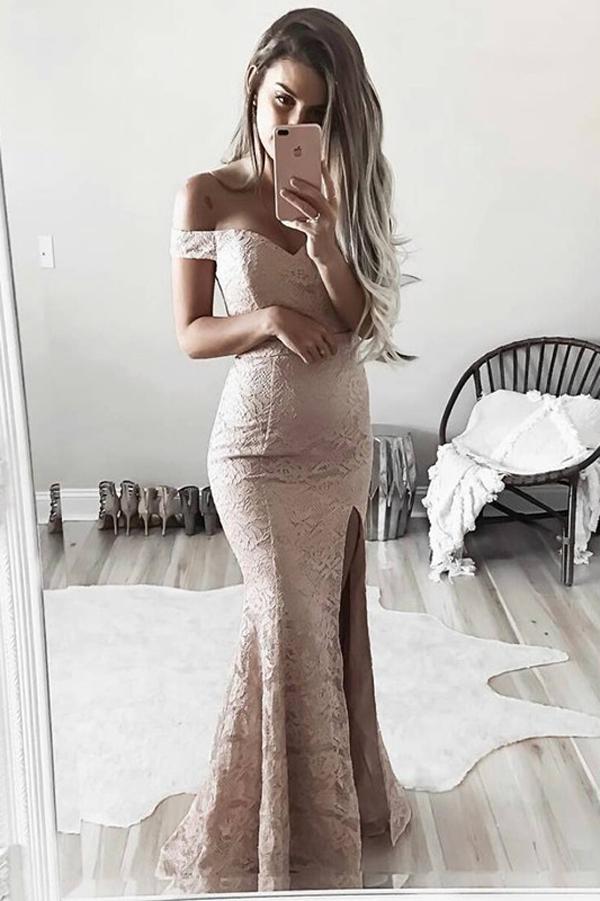 bridesmaid in a long, lace dress is posing next to a huge mirror