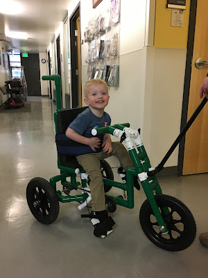 a boy grins from a green PVC bike