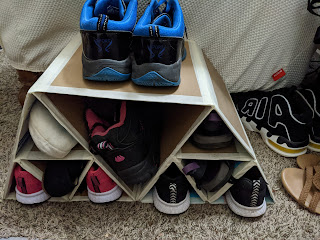 Multiple triangles in two different sizes fit together to make a single shoe rack