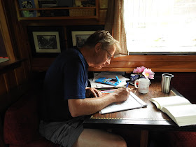 Bill Carlsen, captain of solar canal boat Dragonfly, works on wiring diagrams