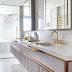 Banheiro branco e cinza com metais dourados e porcelanato marmorizado!
