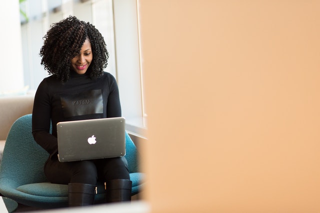 A lady using a MAC laptop