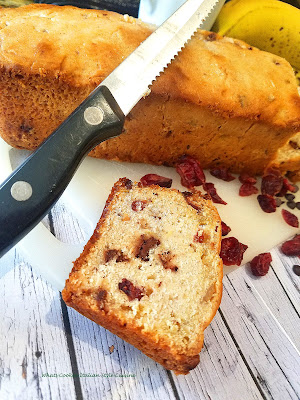Cherry Banana Chocolate Chip Bread Banana bread with dried cherries and chocolate chips taste like a chocolate covered cherry banana bread easy and simple to make banana bread on a cutting board ready to slice up and eat