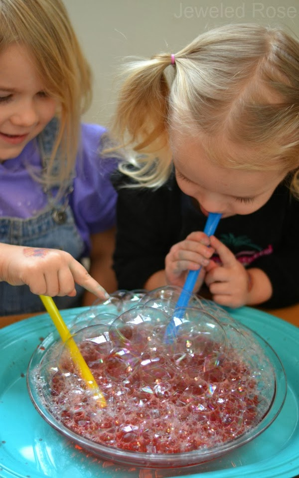 Make bubbles for kids using Kool-aid!  These bubbles are so colorful, making them great for arts, crafts, and sensory play. #koolaidbubbles #scentedbubbles #homemadebubbles #bubblesforkids #bubbles #bubblesrecipe #bubbleart #bubbleactivitiesforkids #bubblepainting #bubbleprints #koolaidrecipes #koolaidhacks #growingajeweledrose