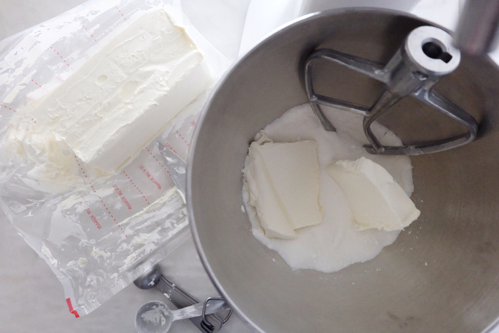 adding cream cheese to mixer