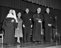 Bishop Charles Helmsing and others on the stage at Notre Dame High School